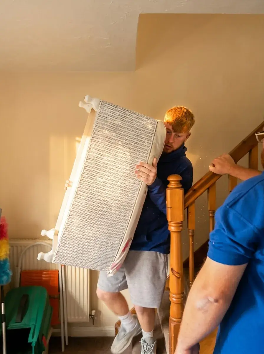 A Twiggy’s crew member carefully carrying furniture down the stairs